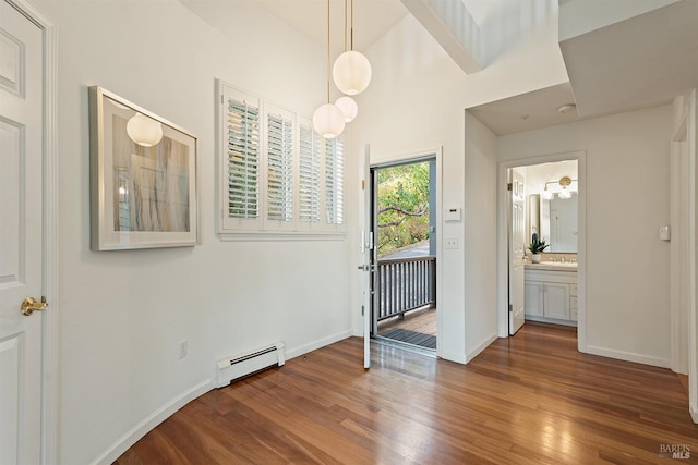 interior space featuring dark hardwood / wood-style floors, sink, access to exterior, and a baseboard heating unit