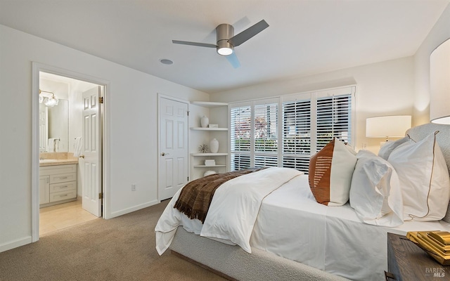 bedroom with connected bathroom, light carpet, and ceiling fan