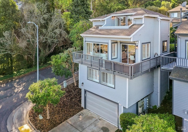 rear view of property with a balcony and a garage