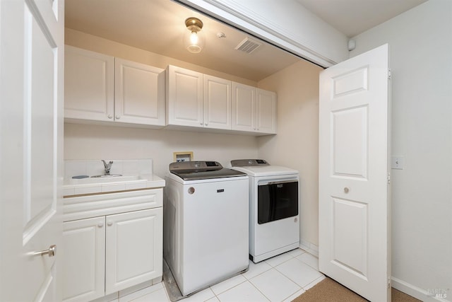 clothes washing area featuring cabinets, light tile patterned flooring, sink, and independent washer and dryer