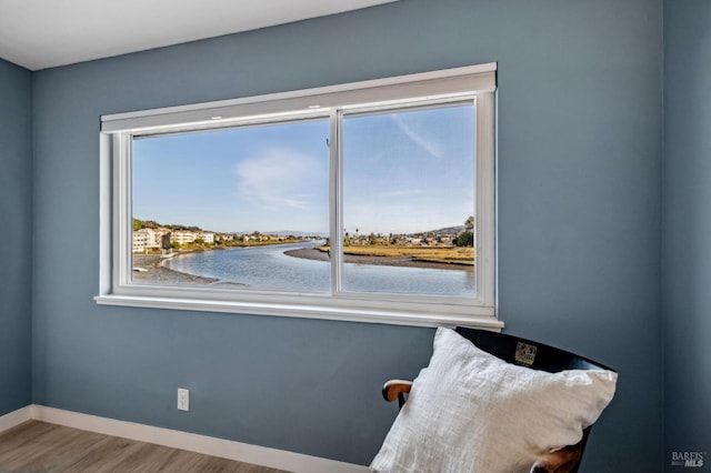 unfurnished room with a water view and hardwood / wood-style flooring