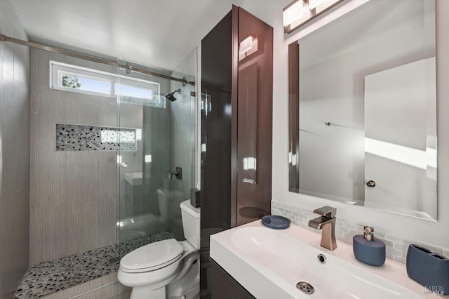 bathroom featuring vanity, toilet, an enclosed shower, and tasteful backsplash