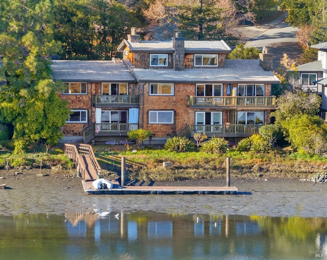 rear view of property featuring a water view and a balcony