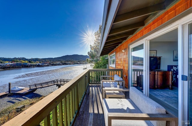 wooden terrace featuring a water and mountain view