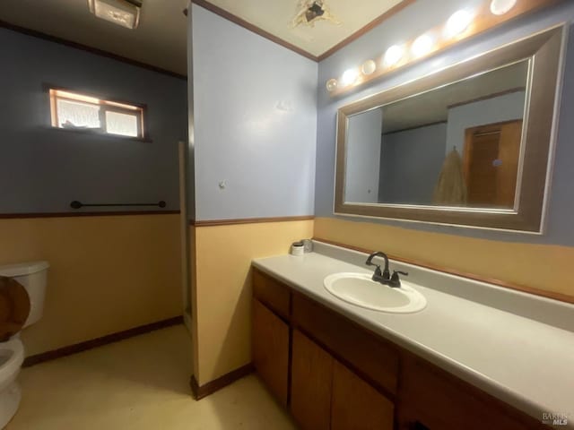 bathroom with vanity, toilet, and crown molding