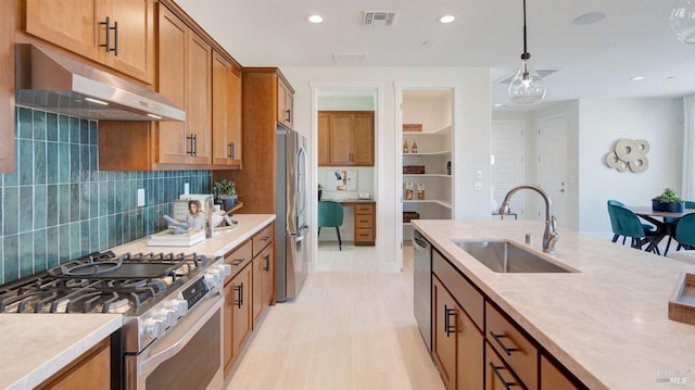 kitchen featuring hanging light fixtures, backsplash, sink, and stainless steel appliances