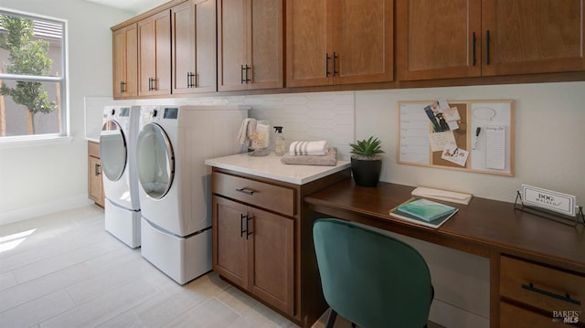 laundry room with washer and dryer, light tile patterned floors, and cabinets