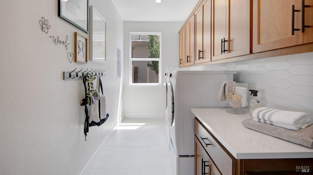 clothes washing area with cabinets, separate washer and dryer, and light tile patterned flooring