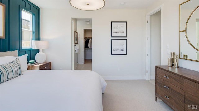 carpeted bedroom featuring a walk in closet and a closet