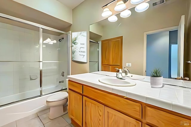 full bathroom featuring tile patterned flooring, vanity, toilet, and enclosed tub / shower combo