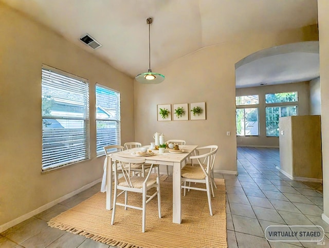 tiled dining area with vaulted ceiling