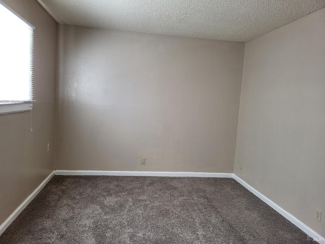 carpeted empty room with a textured ceiling