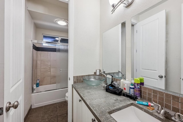 full bathroom featuring combined bath / shower with glass door, tasteful backsplash, vanity, tile patterned flooring, and toilet