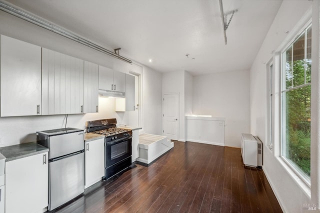 kitchen featuring gas stove, stainless steel refrigerator, plenty of natural light, and dark hardwood / wood-style flooring