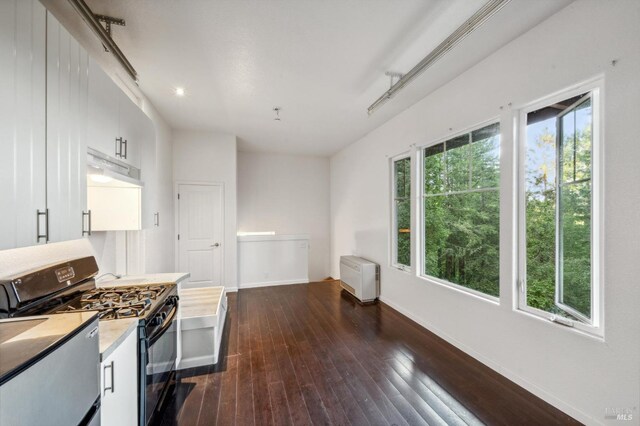 kitchen featuring dark hardwood / wood-style flooring, white cabinetry, and black range with gas cooktop