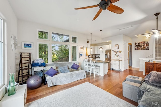 living room with light hardwood / wood-style flooring and ceiling fan