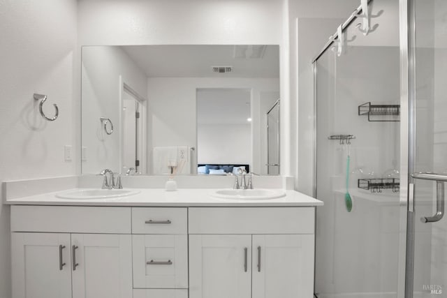 bathroom with a shower with door and vanity