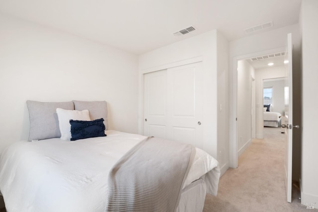 bedroom featuring light colored carpet and a closet