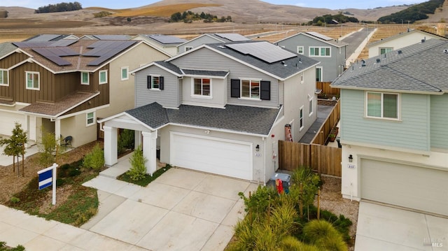 view of front facade featuring a mountain view, a garage, and solar panels