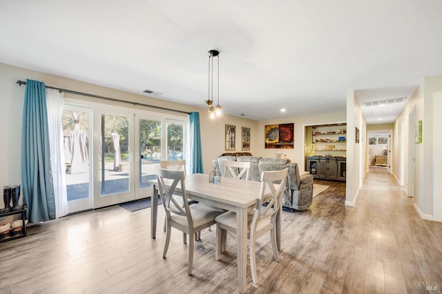 dining area with french doors and light hardwood / wood-style flooring