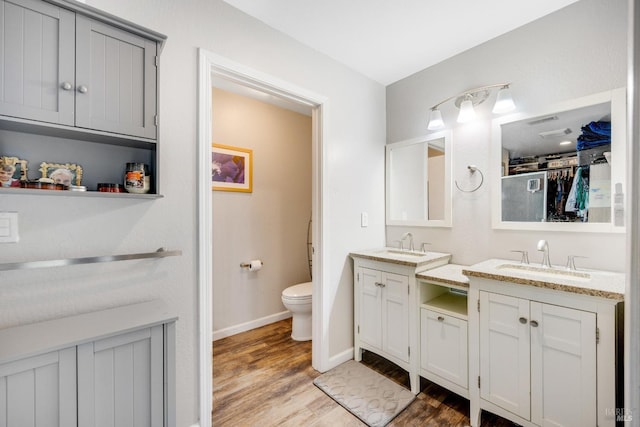 bathroom with hardwood / wood-style flooring, vanity, and toilet