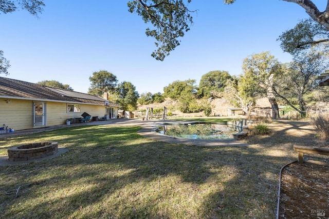 view of yard featuring a pergola and a fire pit