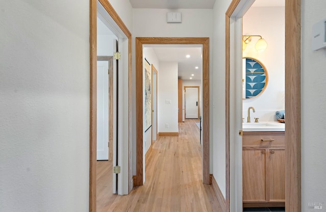 hall featuring light hardwood / wood-style floors and sink