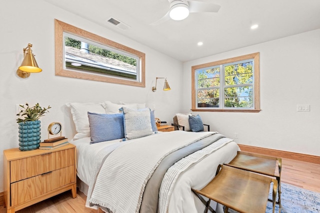 bedroom with ceiling fan, light hardwood / wood-style floors, and multiple windows