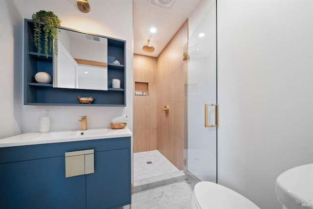 bathroom featuring vanity, toilet, and a shower with shower door