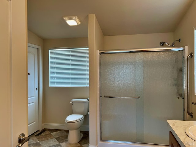 bathroom featuring vanity, toilet, and an enclosed shower