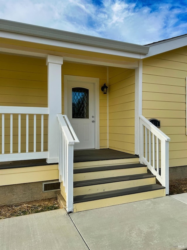 view of exterior entry featuring covered porch