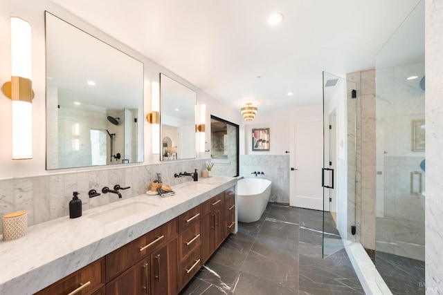 bathroom featuring plus walk in shower, vanity, and tile walls