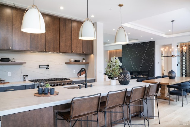 kitchen featuring pendant lighting, light hardwood / wood-style floors, and tasteful backsplash