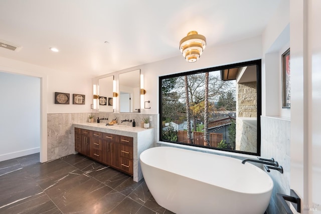 bathroom featuring a washtub and vanity