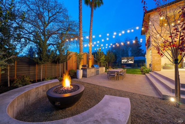 view of patio featuring a fire pit, grilling area, and exterior kitchen