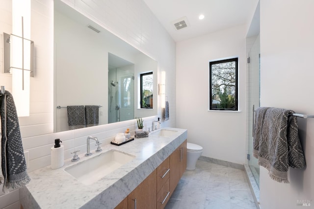 bathroom featuring vanity, a shower with door, toilet, and plenty of natural light