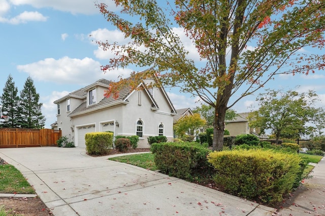 view of property exterior with stucco siding, driveway, and fence