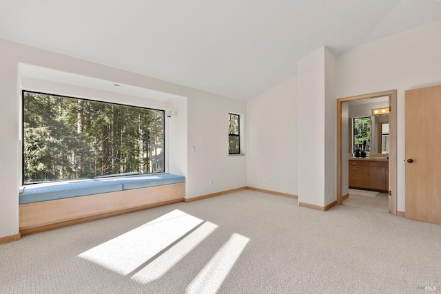 unfurnished room with light colored carpet and lofted ceiling