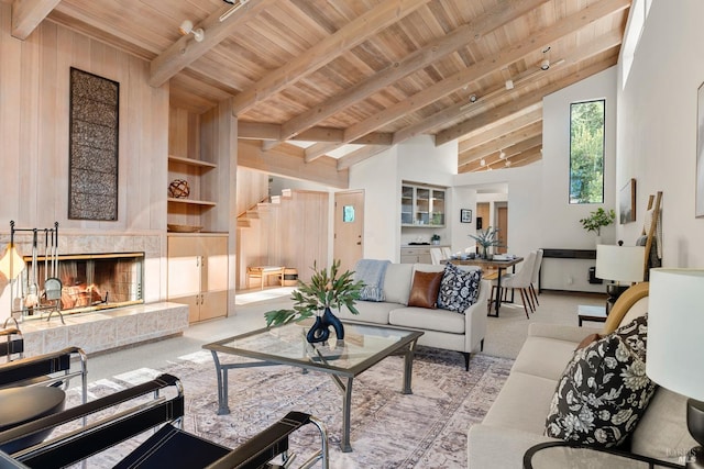 carpeted living room with a fireplace, beam ceiling, high vaulted ceiling, and wood ceiling