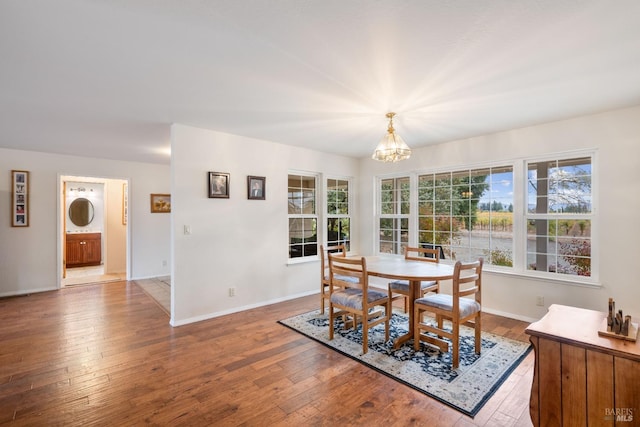 dining area with wood-type flooring and a chandelier