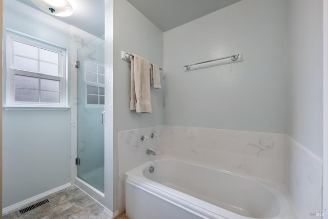 bathroom featuring shower with separate bathtub