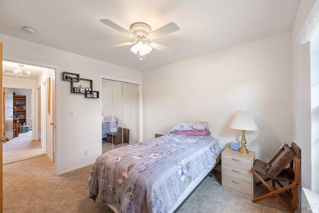 bedroom with light carpet, ceiling fan with notable chandelier, and a closet