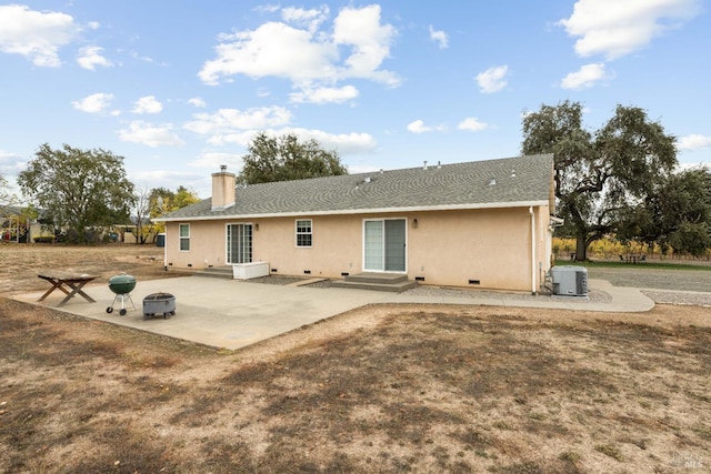 rear view of house featuring a fire pit, central AC, and a patio