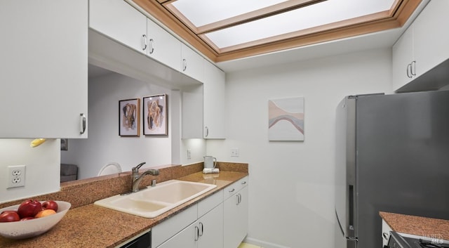 kitchen with white cabinets, stainless steel fridge, and sink