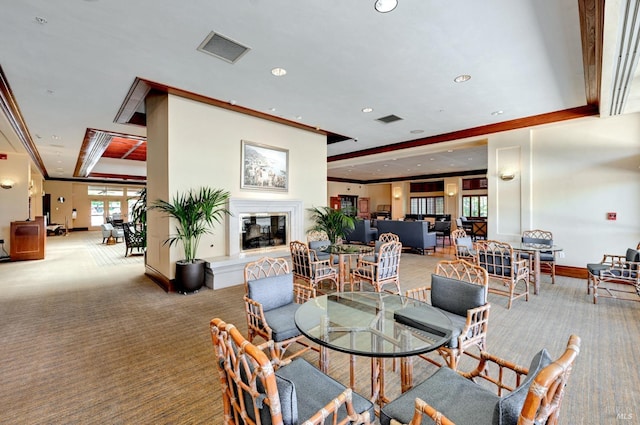 carpeted dining space with a tray ceiling and crown molding