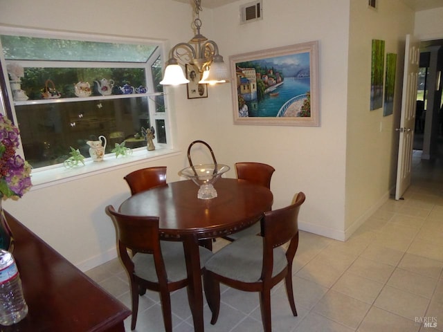 dining room with light tile patterned floors and a chandelier