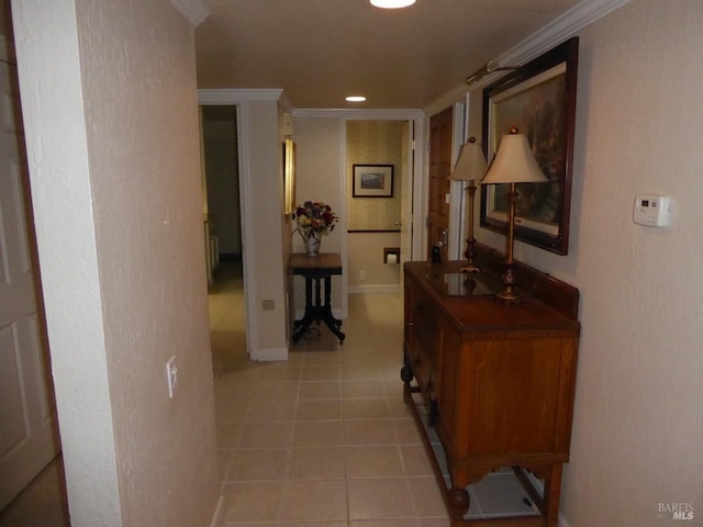 hall featuring light tile patterned flooring and crown molding