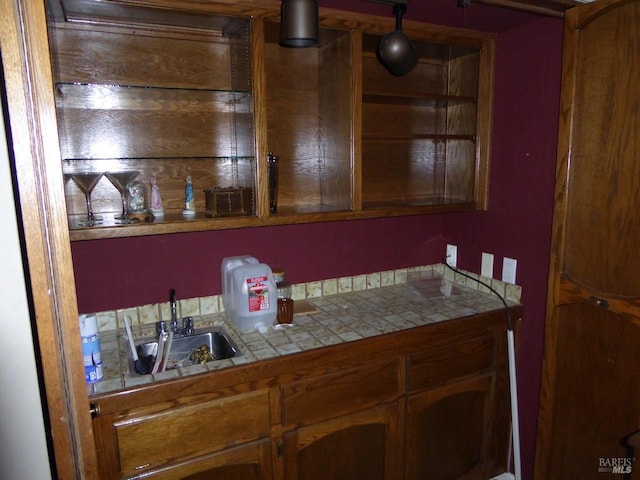 bar with tile countertops and sink