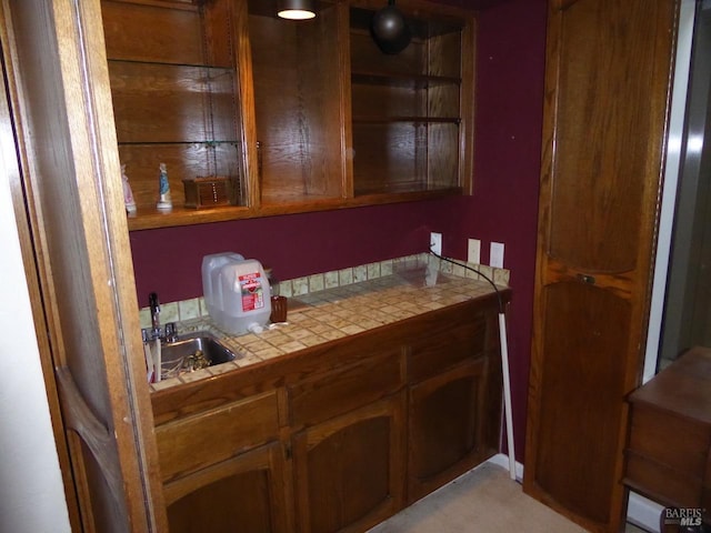 bar with tile countertops and sink