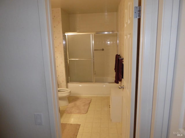 bathroom featuring toilet and enclosed tub / shower combo